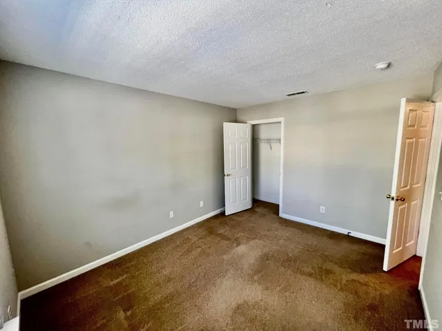 an empty room with wooden floor and entrance