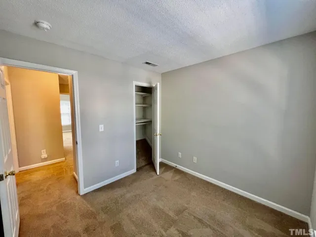 an empty room with closet and windows