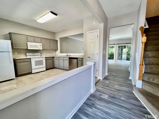 a large kitchen with cabinets wooden floor and stainless steel appliances