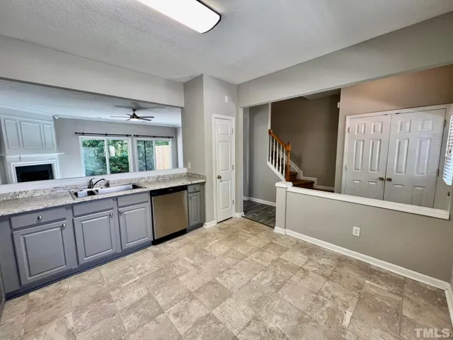 a large white kitchen with a sink and cabinets