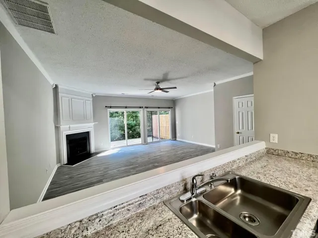 a view of an empty room with a fireplace and a window