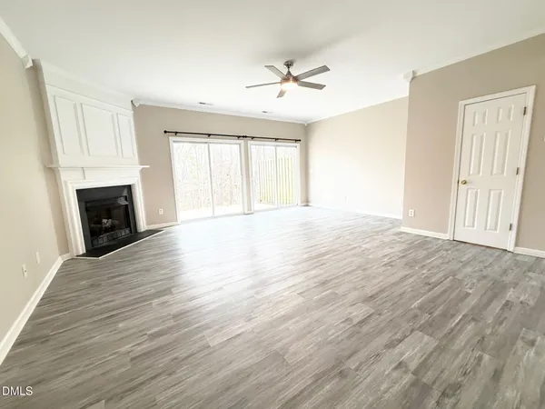 a view of an empty room with a fireplace and a window