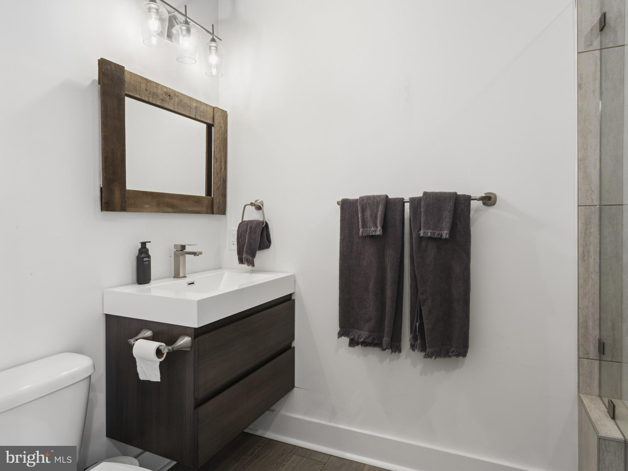 1404 Olive Street Baltimore, MD 21230 - Photo 18 of 38 a bathroom with a toilet sink vanity and mirror