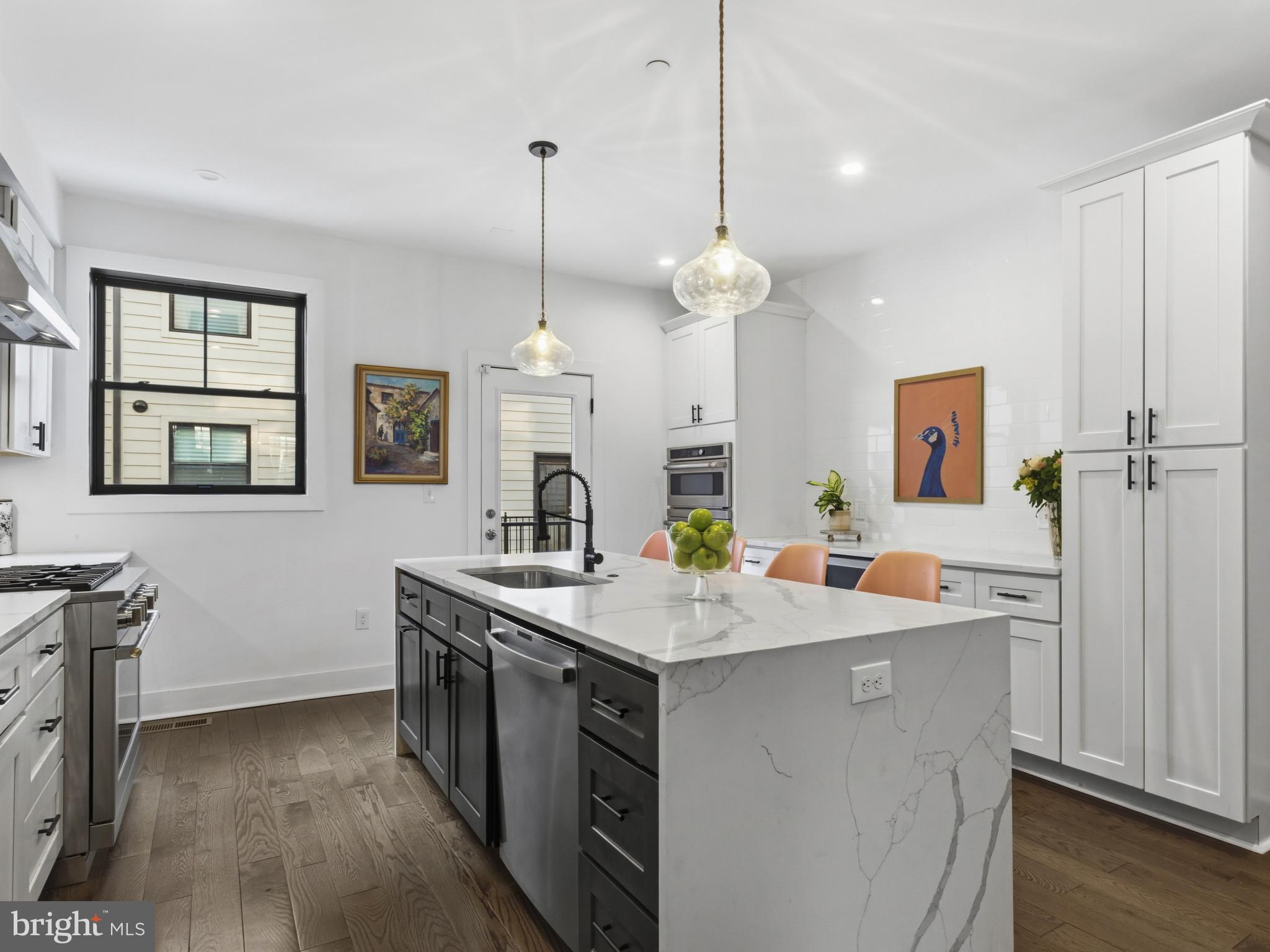 1404 Olive Street Baltimore, MD 21230 - Photo 9 of 38 a view of a kitchen counter space a sink stainless steel appliances and wooden floor