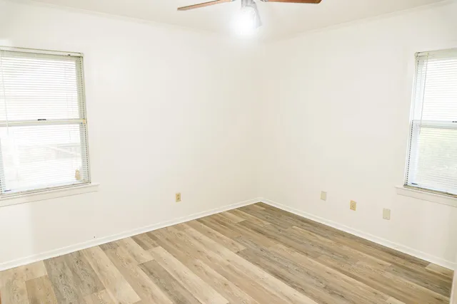 a view of empty room with wooden floor