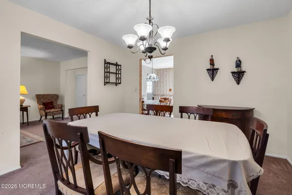 a view of a dining room with furniture and chandelier