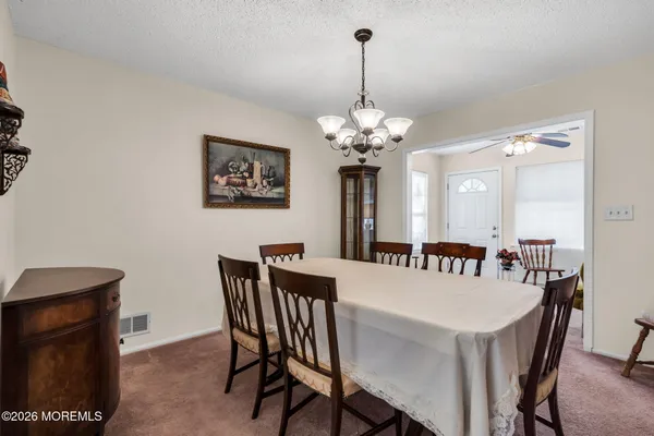 a view of a dining room with furniture a chandelier and wooden floor