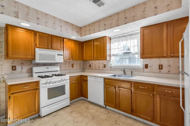 a kitchen with sink a stove and cabinets