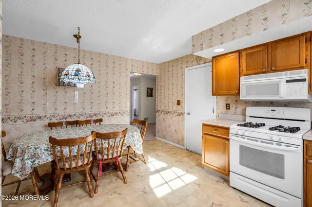 a dining hall with a stove a sink and a refrigerator