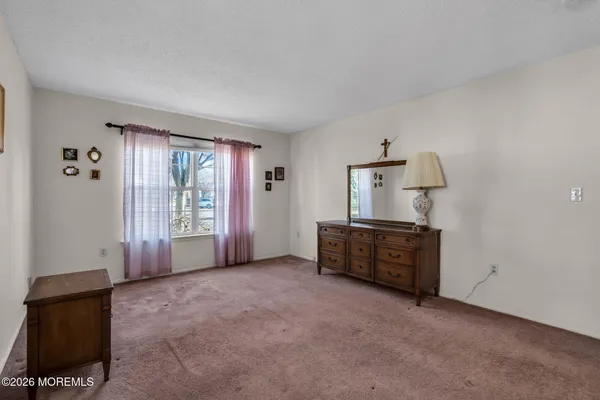 an empty room with windows and cabinet