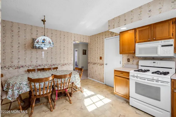 a dining hall with a stove a sink and a refrigerator