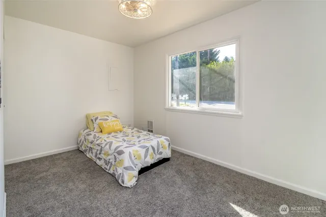 a bed sitting in a bedroom next to a window