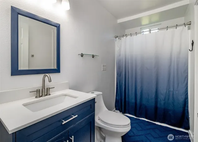 a bathroom with a sink vanity mirror and toilet
