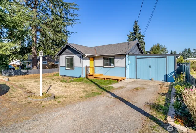 a view of a house with a backyard and wooden fence