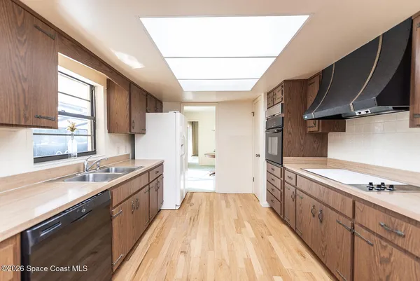 a view of a kitchen with a sink and wooden floor