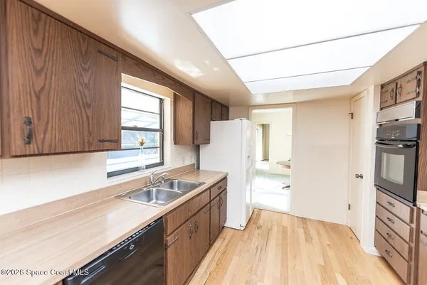 a kitchen with granite countertop a sink stove and refrigerator
