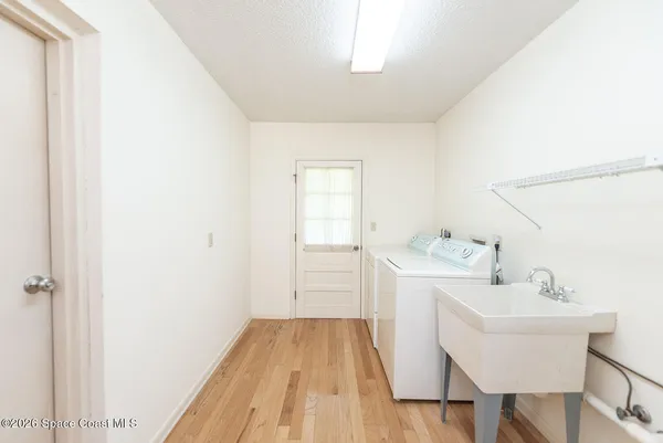 a hallway with a sink and a wooden floor