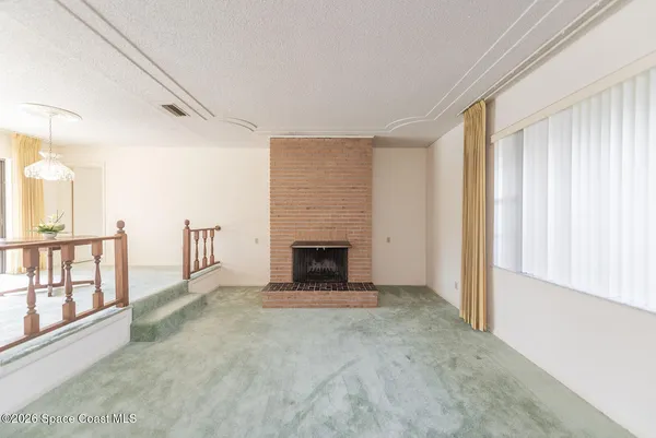 a view of a livingroom with an empty space and a fireplace
