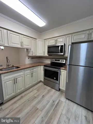 a kitchen with granite countertop a refrigerator and a stove top oven