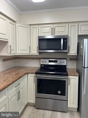 a kitchen with cabinets stainless steel appliances and a sink
