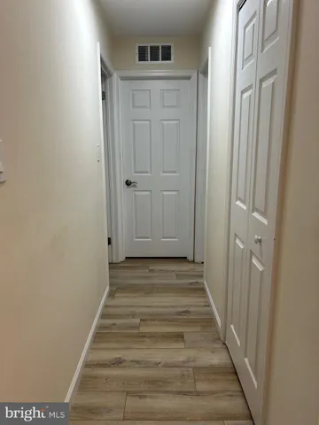 a view of a hallway with wooden floor and entryway