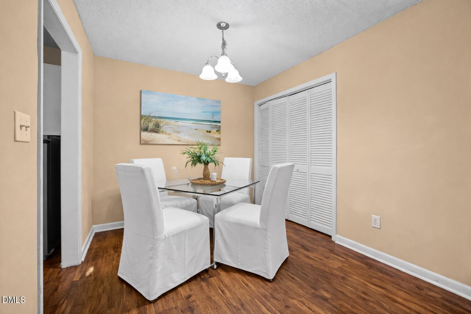 5816 Pointer Drive, Unit 102 Raleigh, NC 27609 - Photo 9 of 25 a dining room with furniture a chandelier and wooden floor