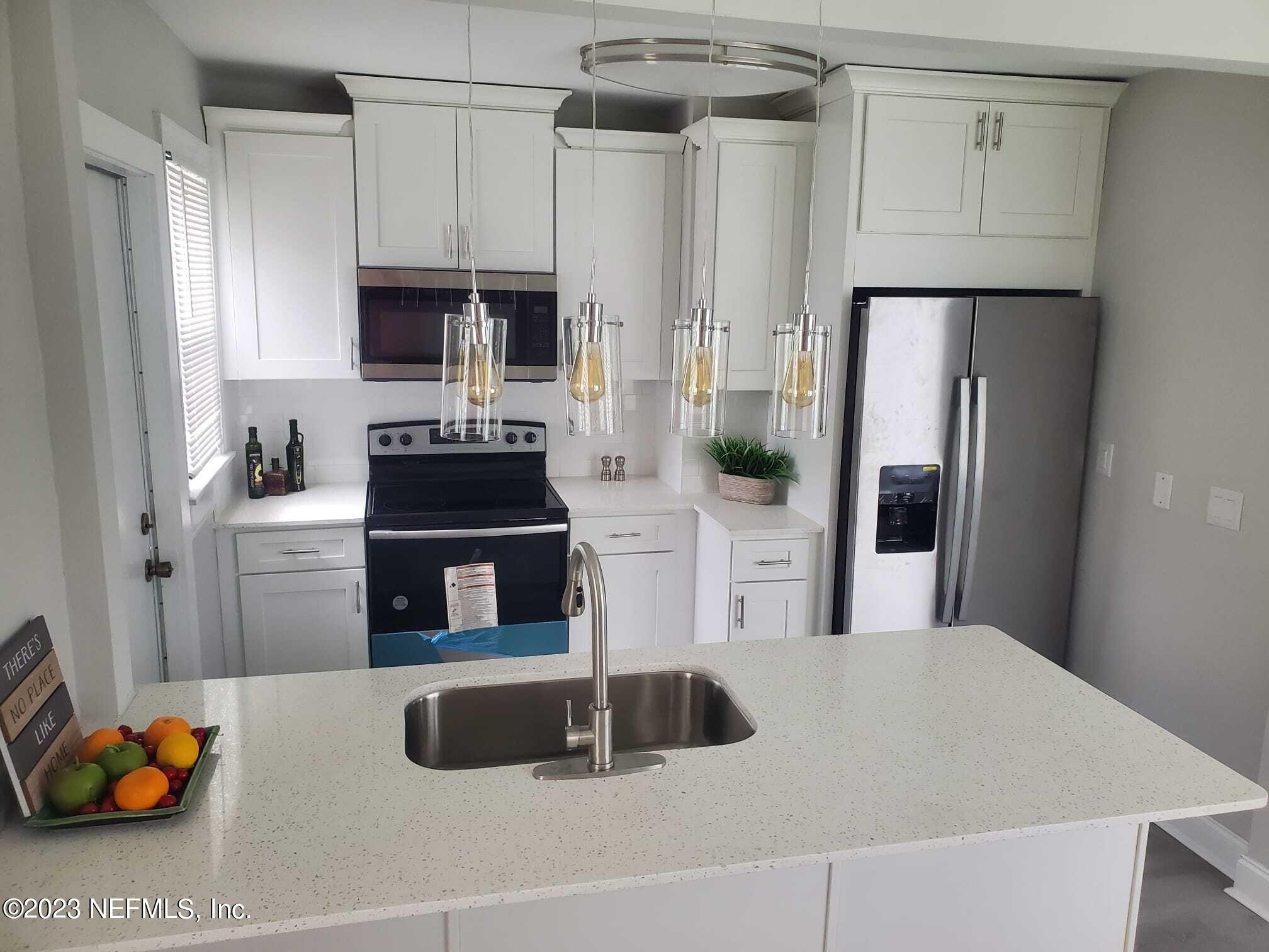 5232 Sunderland Road Jacksonville, FL 32210 - Photo 3 of 17 a kitchen with stainless steel appliances granite countertop a sink refrigerator and cabinets