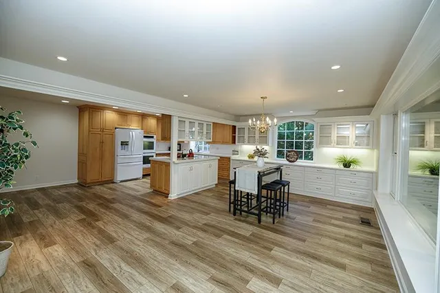 a kitchen with stainless steel appliances granite countertop wooden floor window and cabinets