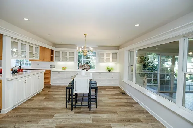 a view of an empty room with wooden floor and floor to ceiling windows