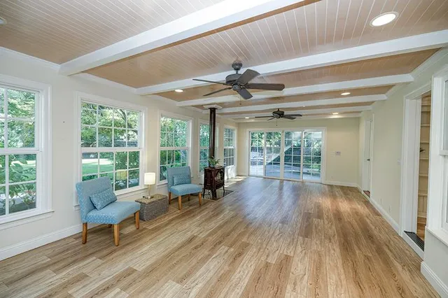 a view of a big room with wooden floor and windows