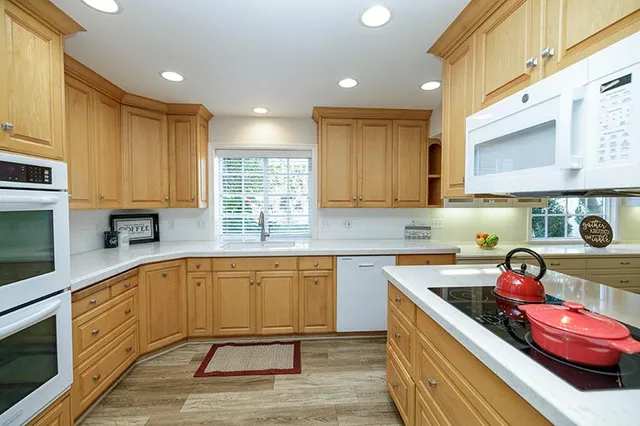 a kitchen with stainless steel appliances granite countertop a sink refrigerator and cabinets