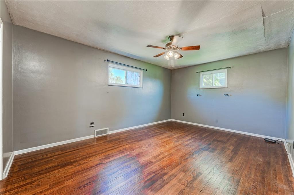 717 Morgantown Road Uniontown, PA 15401 - Photo 16 of 23 an empty room with wooden floor chandelier fan and windows