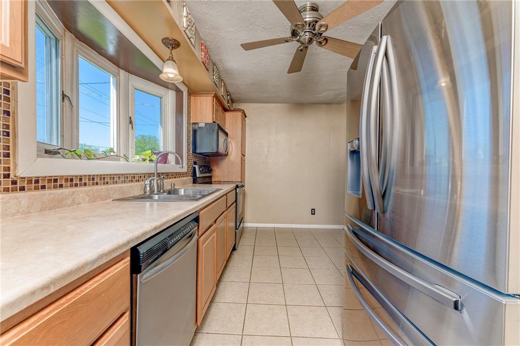 717 Morgantown Road Uniontown, PA 15401 - Photo 9 of 23 a kitchen with stainless steel appliances granite countertop a sink and a refrigerator