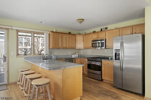 a kitchen with stainless steel appliances granite countertop a sink a stove counter space and cabinets