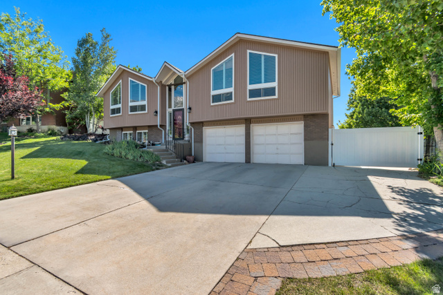 9832 Falconhurst Drive Sandy, UT 84092 - Photo 2 of 29 Split-level residence featuring a two-car garage, concrete driveway, and a fenced side yard