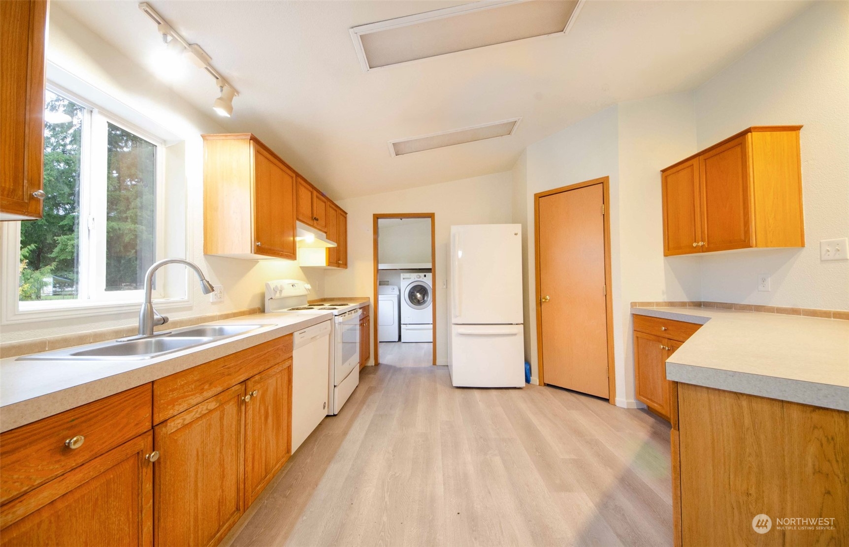 8827 173rd Avenue Southwest Rochester, WA 98579 - Photo 4 of 15 a large kitchen with a sink a window and stainless steel appliances