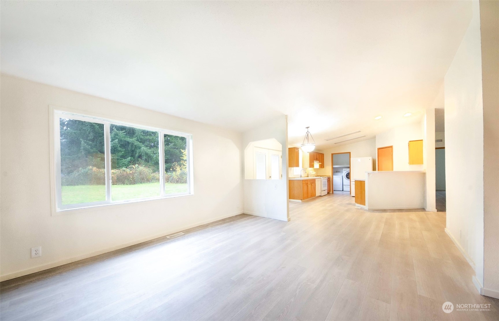 8827 173rd Avenue Southwest Rochester, WA 98579 - Photo 6 of 15 a view of a big room with wooden floor and windows