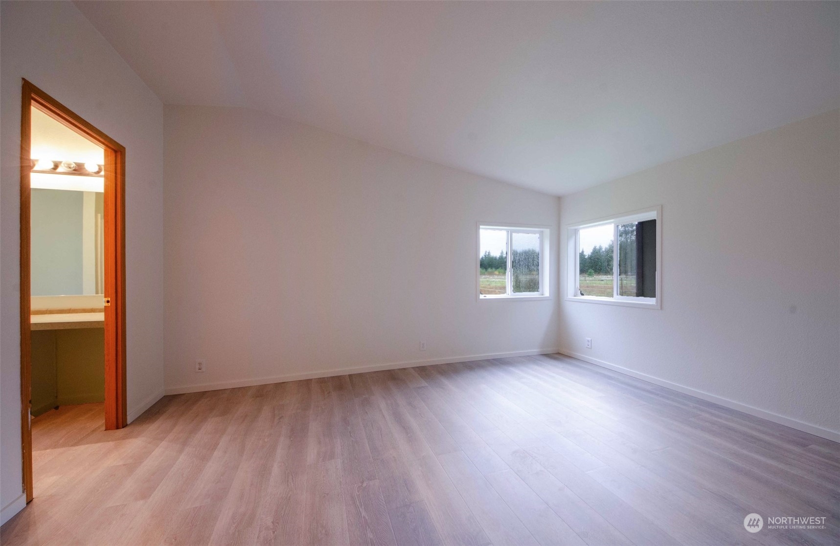 8827 173rd Avenue Southwest Rochester, WA 98579 - Photo 9 of 15 an empty room with wooden floor and windows