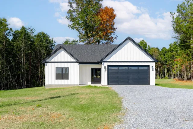 a front view of a house with yard and garage