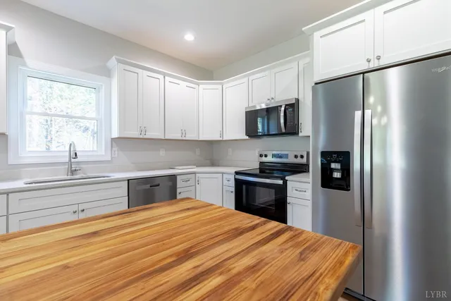 a kitchen with stainless steel appliances a refrigerator sink and microwave