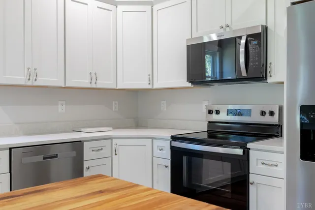 a kitchen with stainless steel appliances granite countertop a sink a stove and microwave