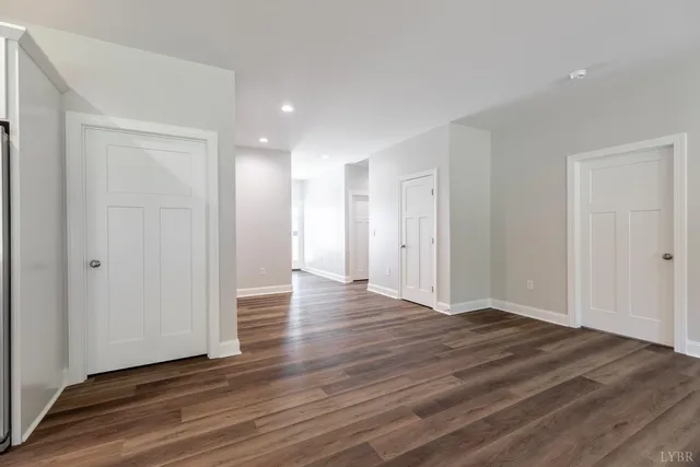 a view of an empty room with wooden floor and closet