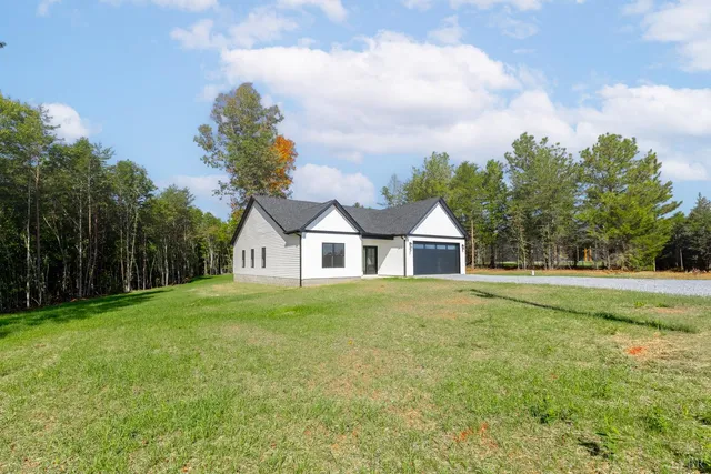 a front view of a house with a yard and trees
