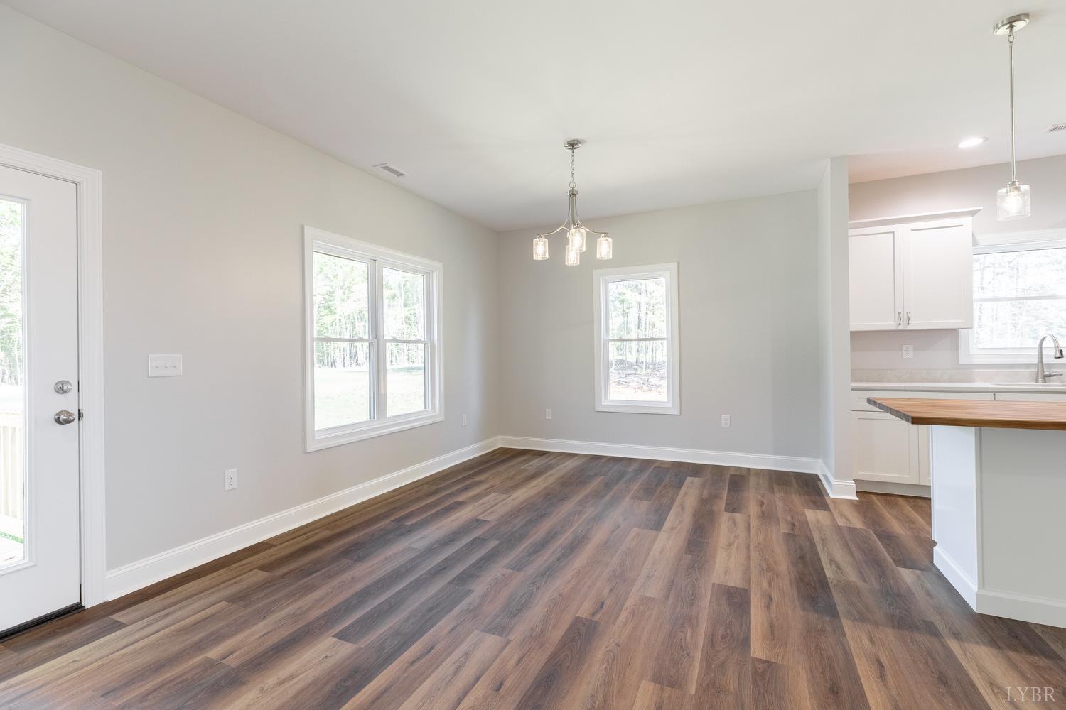 757 Down Creek Road Brookneal, VA 24528 - Photo 6 of 49 an empty room with wooden floor and windows