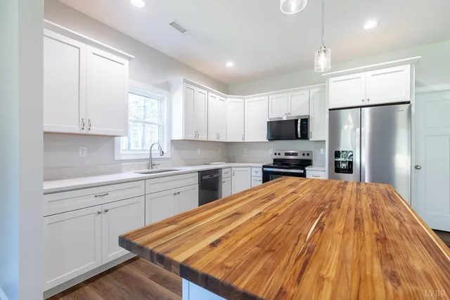 a kitchen with granite countertop a refrigerator stove top oven and sink
