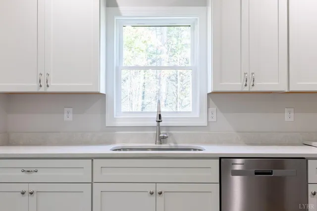 a kitchen with granite countertop white cabinets and a sink