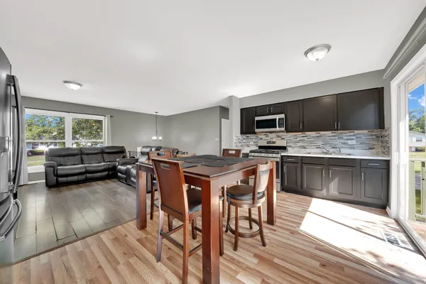 a kitchen with stainless steel appliances a stove a sink dishwasher and a refrigerator with wooden floor