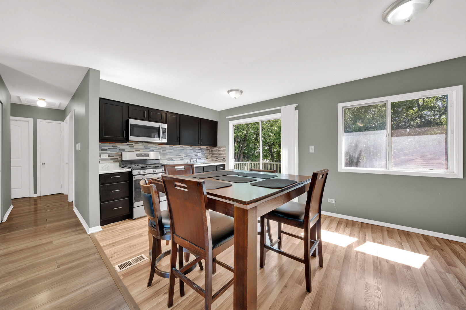 17303 Apple Tree Drive Hazel Crest, IL 60429 - Photo 10 of 23 a kitchen with a table chairs refrigerator and microwave