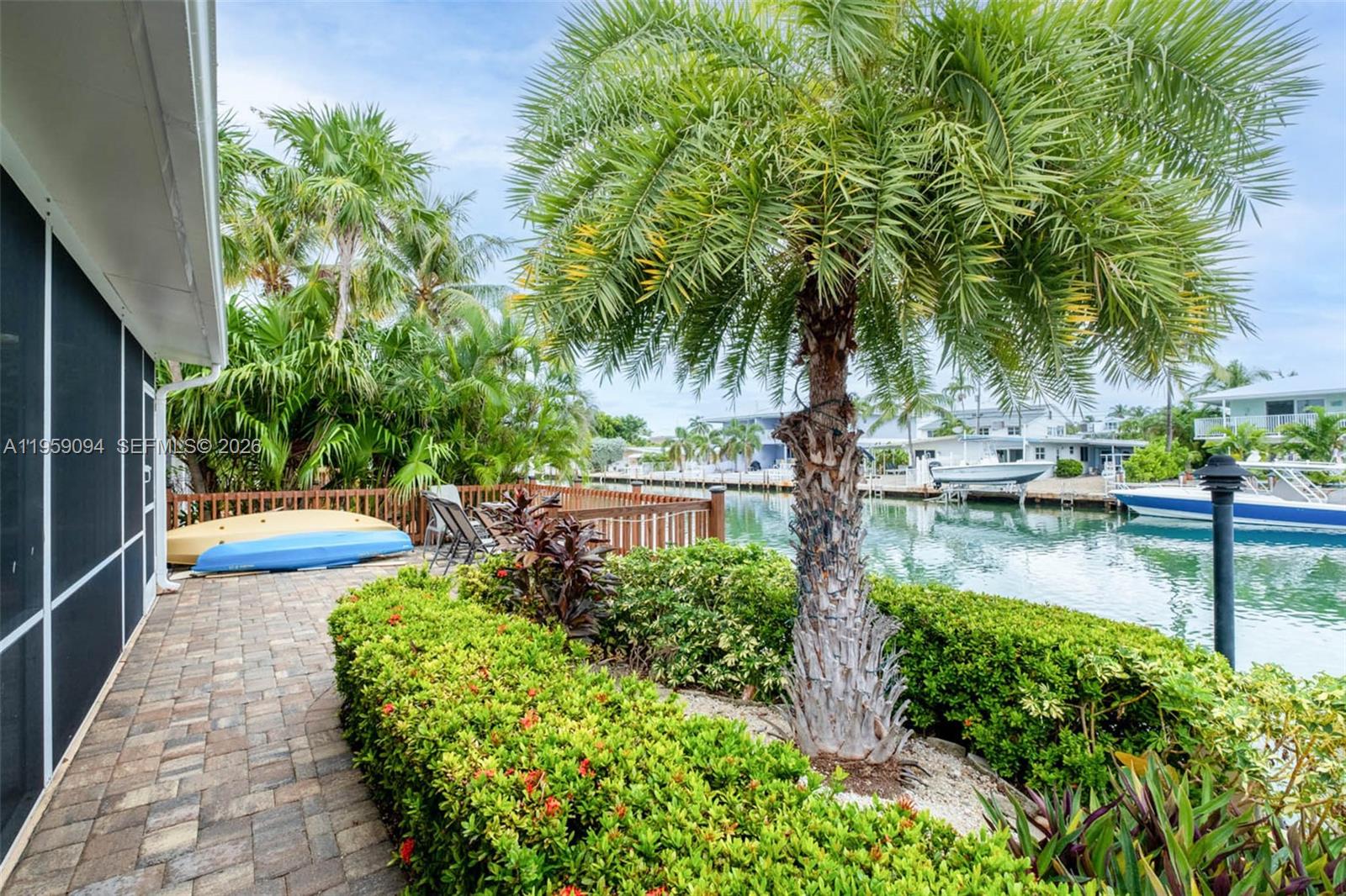 410 10th Street Key Colony Beach, FL 33051 - Photo 22 of 62 a view of swimming pool with lawn chairs plants and palm trees