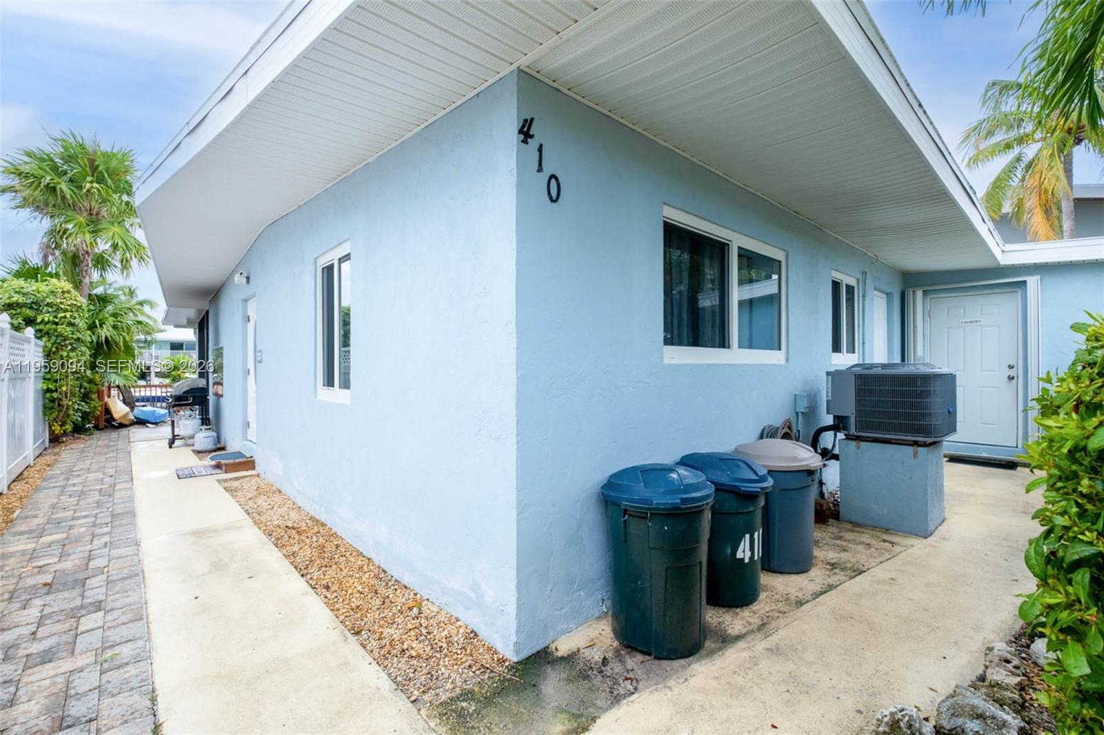 410 10th Street Key Colony Beach, FL 33051 - Photo 33 of 62 a view of a patio with table and chairs potted plants and floor to ceiling window
